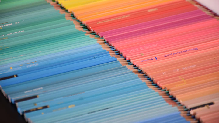 Coloured pencils arranged in a rainbow gradient