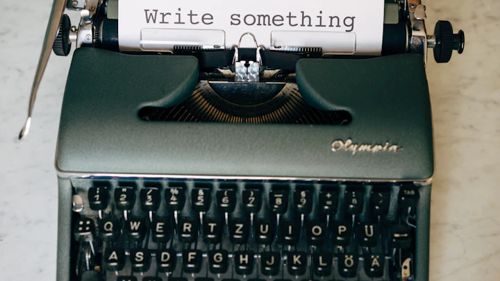 A vintage typewriter with a sheet of paper reading Write something