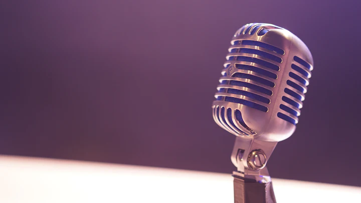 A vintage microphone against a soft purple background