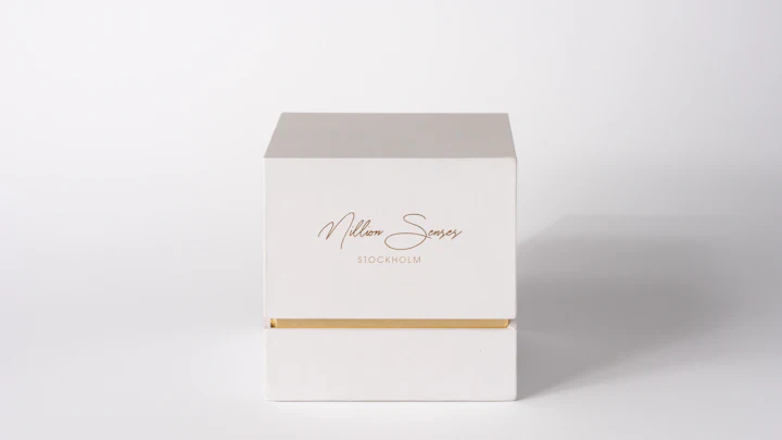 A white gift box with gold accents on a white background