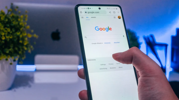 A hand holding a phone open to a search page