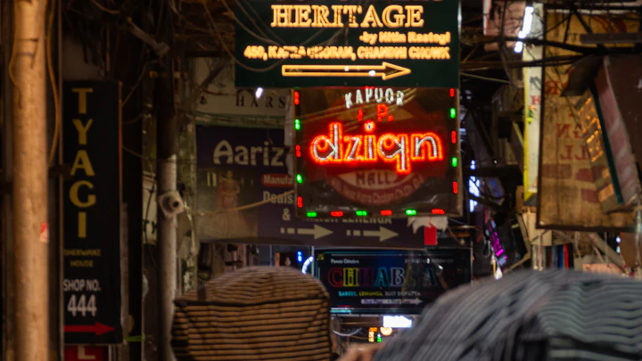 Crowds and neon shop signs at Chandni Chowk market in Old Delhi at night